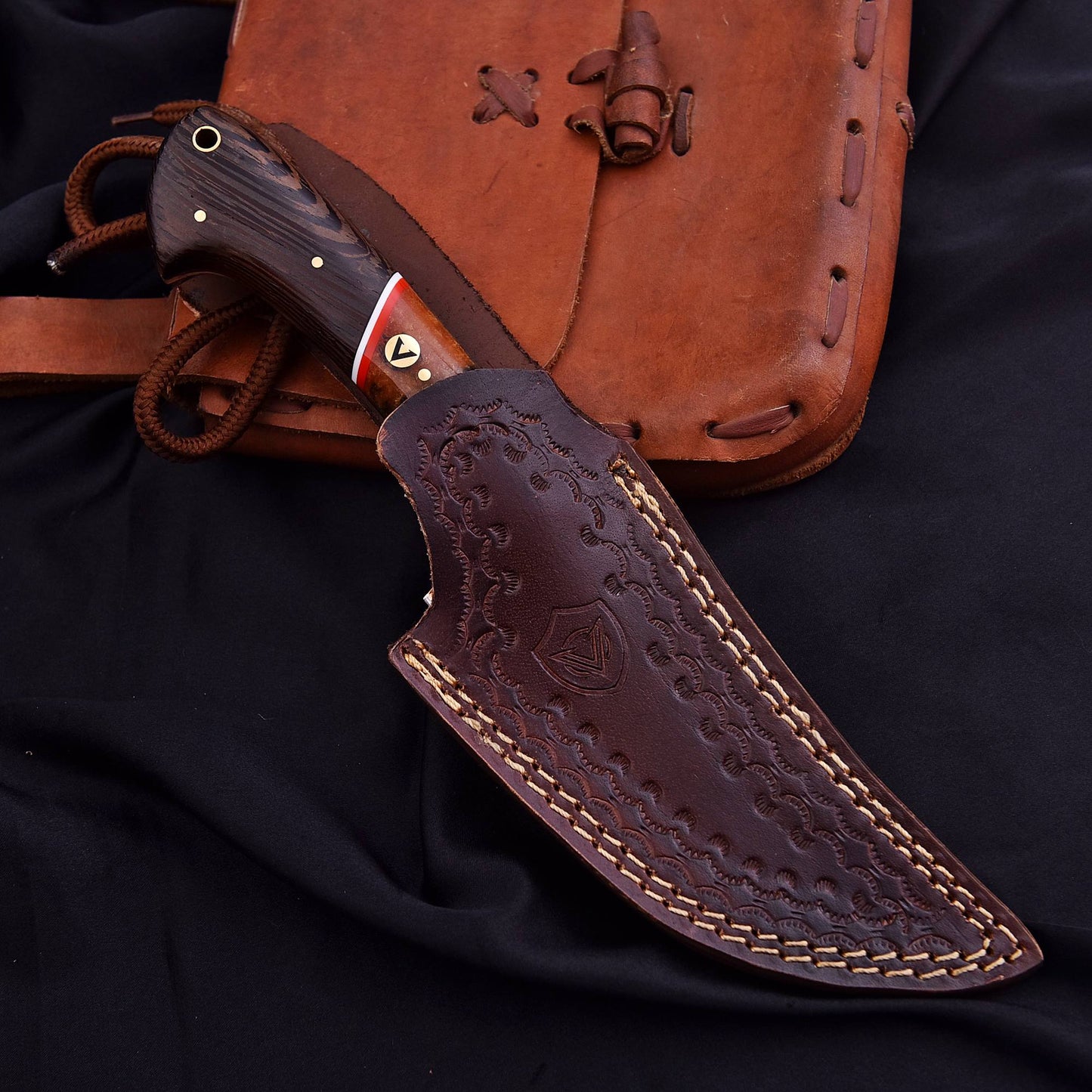 Knife with leather sheath on a dark background