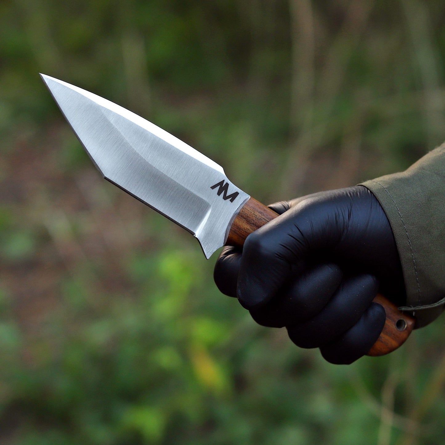 AM Frontier hunting knife held in hand, highlighting balance, full tang build, and contoured rosewood grip for secure outdoor use.