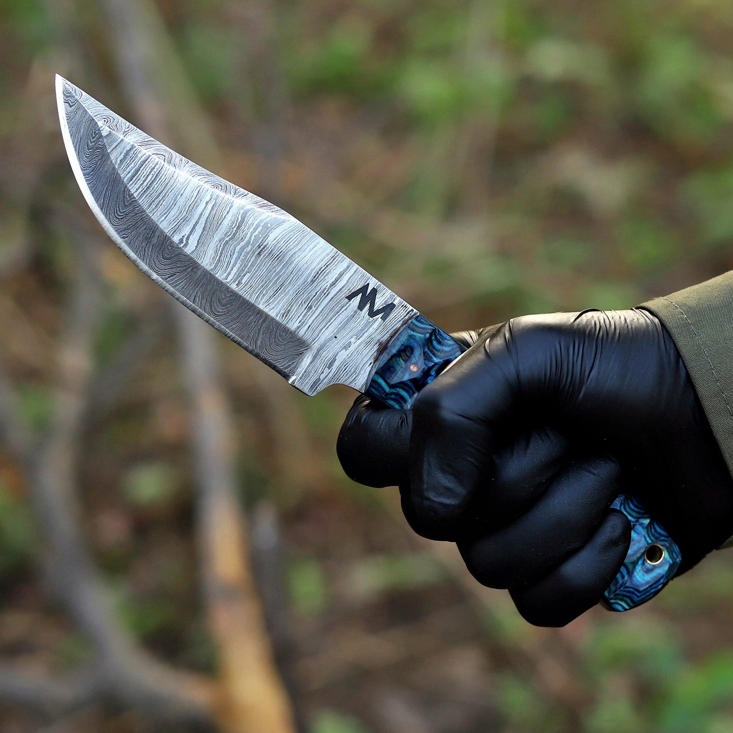 AM Helix Damascus knife held in hand showing ergonomic blue wood handle and balance