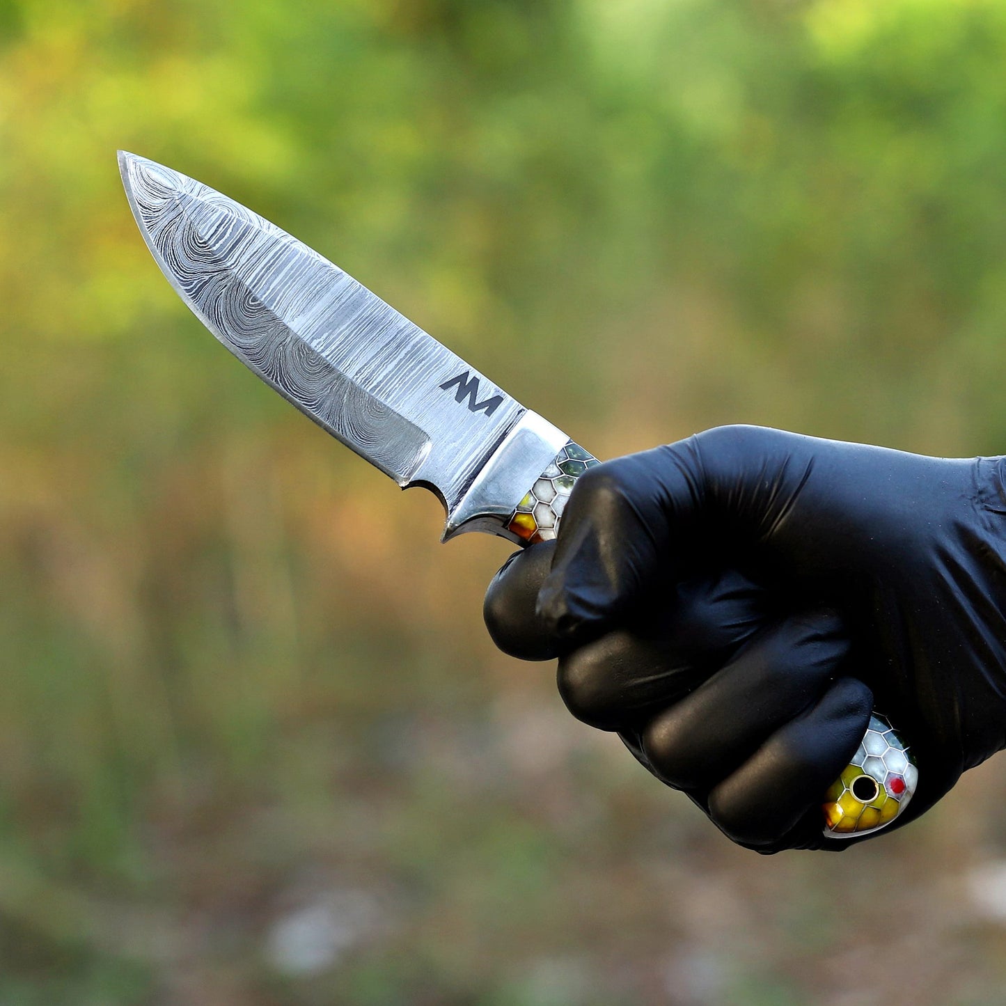 AM Hexfire Damascus knife held in hand showing full tang balance and ergonomic grip.