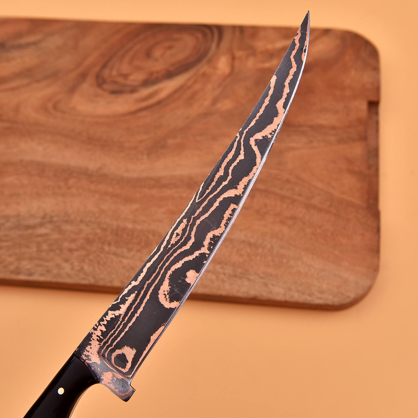 Close-up of the copper-layered Damascus blade pattern on the AM Inferno fillet knife