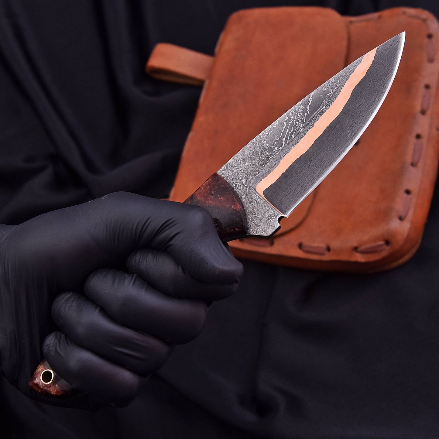 Close-up of copper Cumai Damascus blade with etched wave pattern