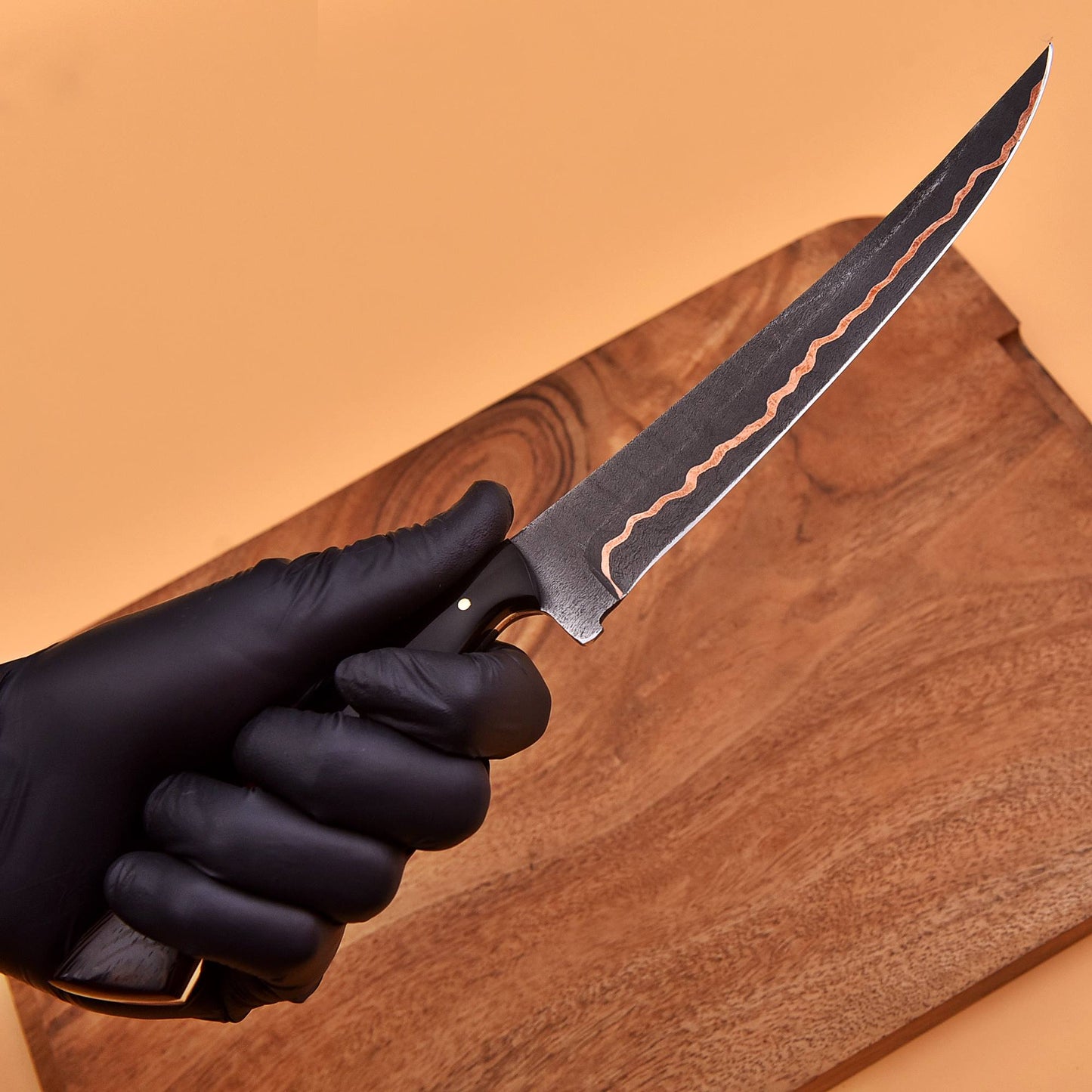Close-up of copper-lined Damascus blade on the AM Vortex fillet knife