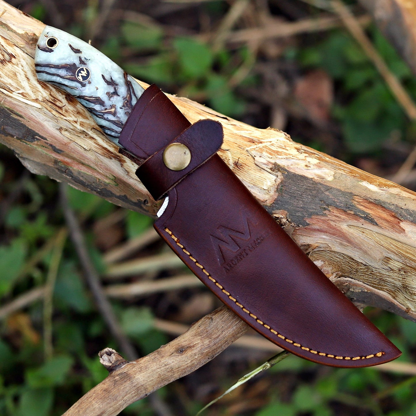 AM Shard Damascus knife sheathed in premium leather vertical carry case — outdoor carry-ready design.