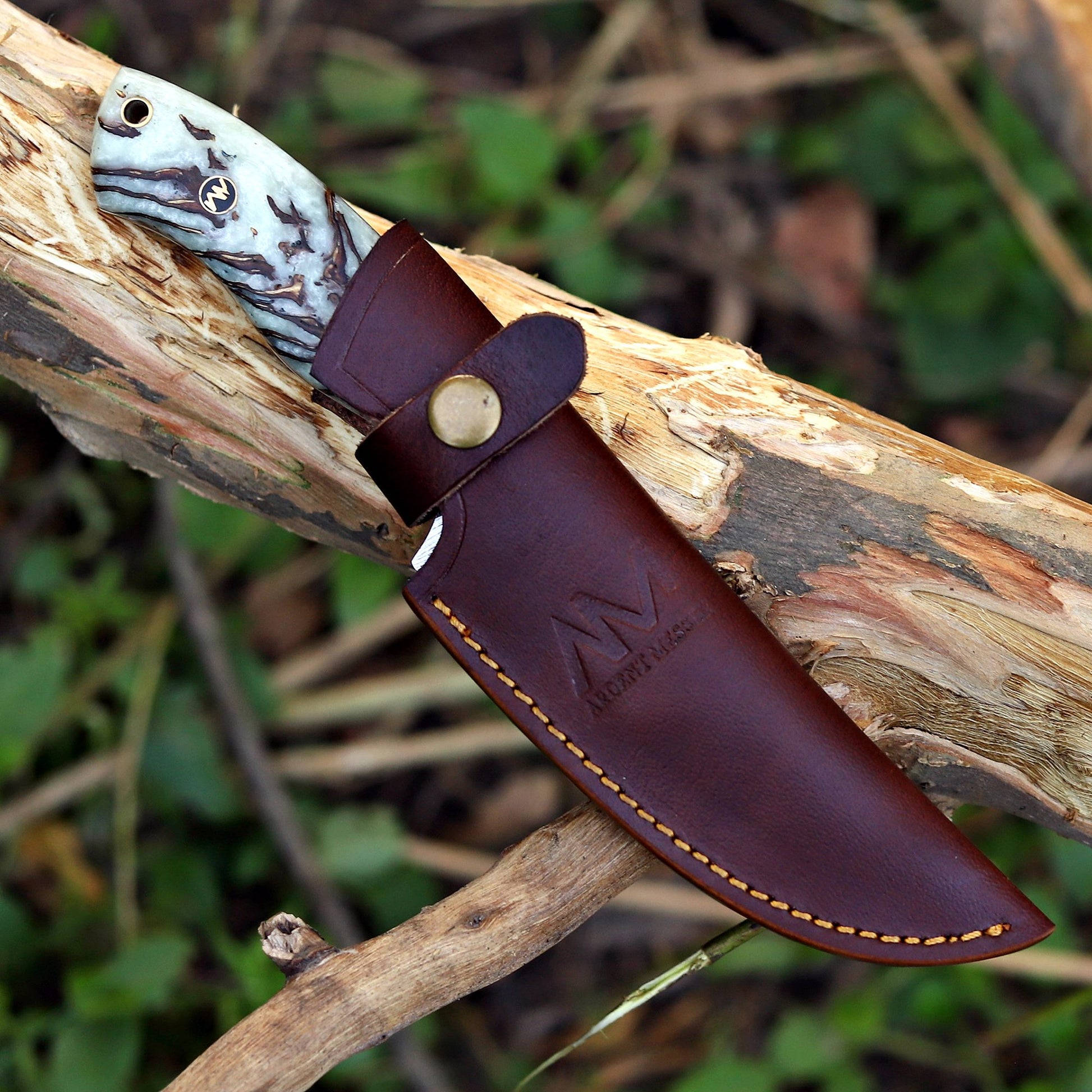 AM Shard Damascus knife sheathed in premium leather vertical carry case — outdoor carry-ready design.